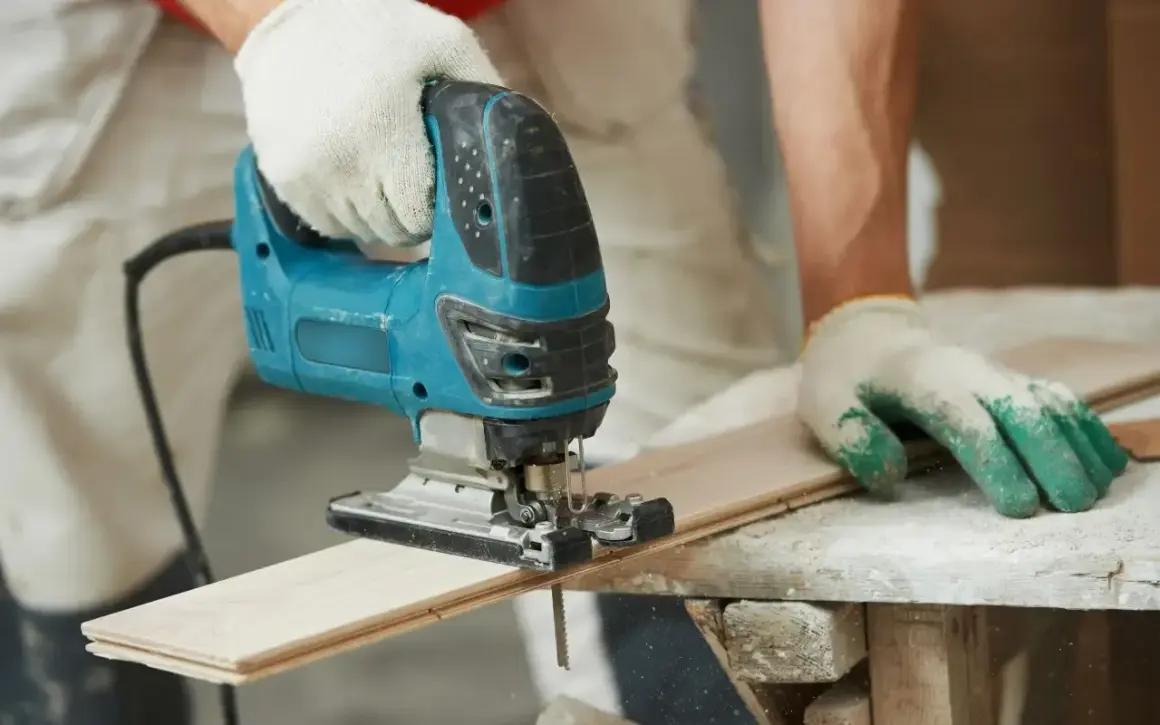 Main tenant utilise une scie sauteuse pour apprendre comment couper droit.