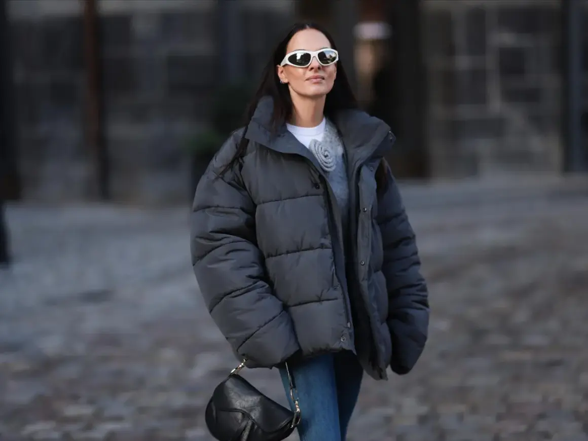 Frau mit Daunenjacke, die sie ohne Trockner wäscht, trägt weiße Sonnenbrille und schwarze Tasche.