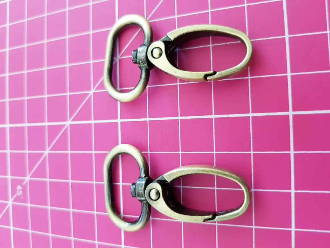 Dos mosquetones de latón envejecido, perfectos para tu mochila o llavero.