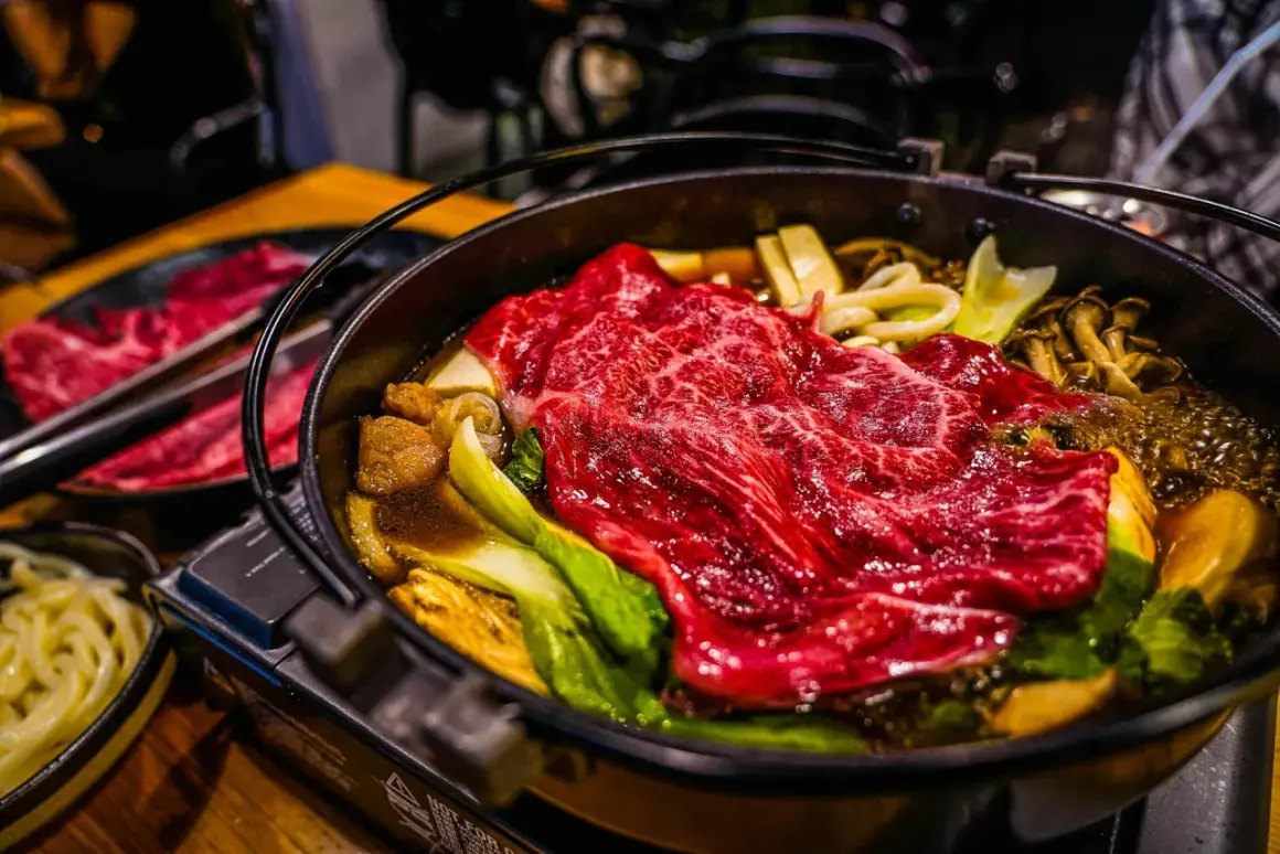 Ein dampfender Hot Pot Japan mit zartem Rindfleisch, Pilzen und Gemüse.