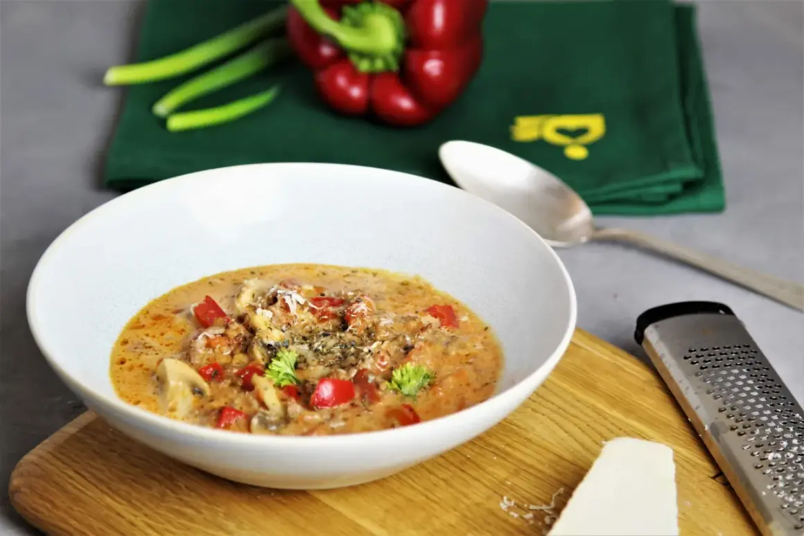 Herzhaftes Pizzasuppe Rezept: cremige Suppe mit Paprika, Pilzen und Käse, garniert mit Petersilie. Perfekt für kalte Tage!