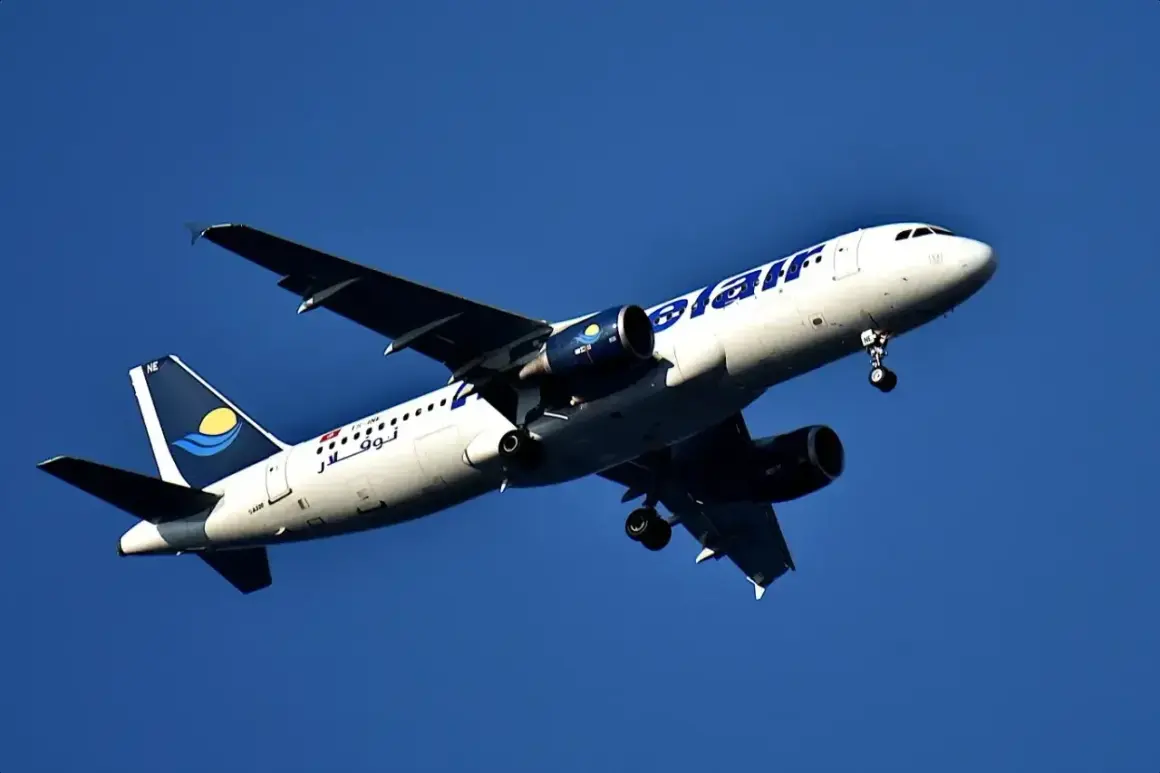 Samolot linii nouvelair z wysuniętym podwoziem wznosi się na tle błękitnego nieba.