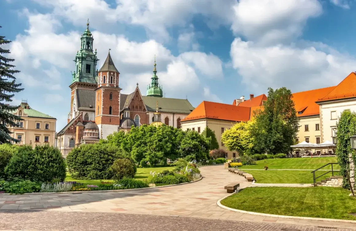 Wawel cennik: malowniczy widok na zamek i katedrę z zielonymi ogrodami i brukowanymi alejkami.