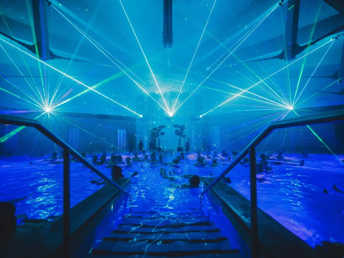 Blaue Laserstrahlen tanzen über einem Pool voller Menschen. Ein unvergessliches Erlebnis bei den Veranstaltungen in Bad Windsheim.