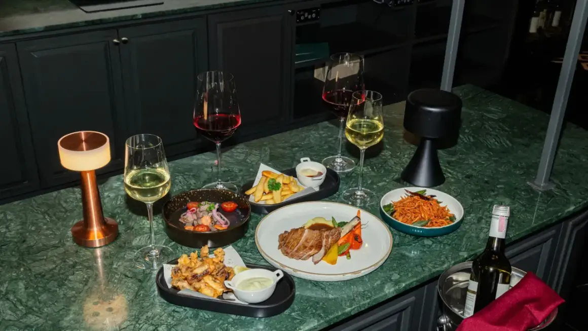 Elegancka kolacja z kieliszkiem chardonnay wino, stekiem, frytkami i sałatką.