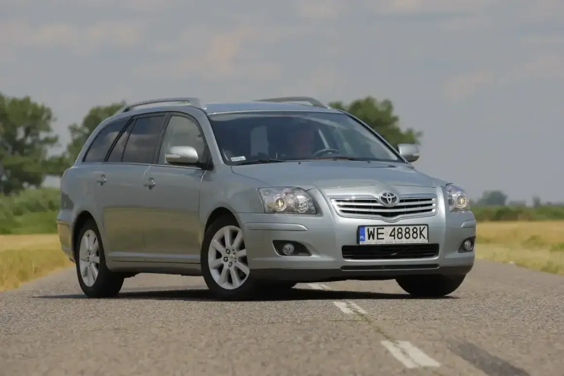Srebrny kombi Toyota Avensis 1.8 benzyna na drodze.