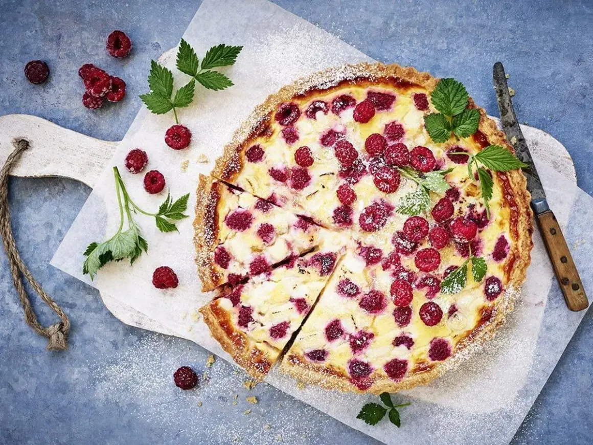 En härlig hallonpaj, perfekt för ett somrigt hallonpaj recept. Garnerad med färska hallon och myntablad.