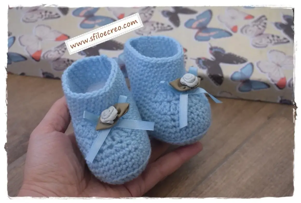 Schemi scarpine neonato uncinetto facilissime. Deliziose scarpine azzurre all'uncinetto, perfette per un bebè, con fiocco e fiorellino.