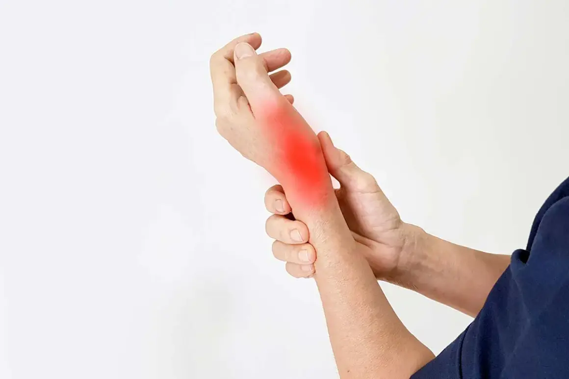 Mano con un'area rossa brillante sul polso, che indica dolore al polso che si irradia al braccio.