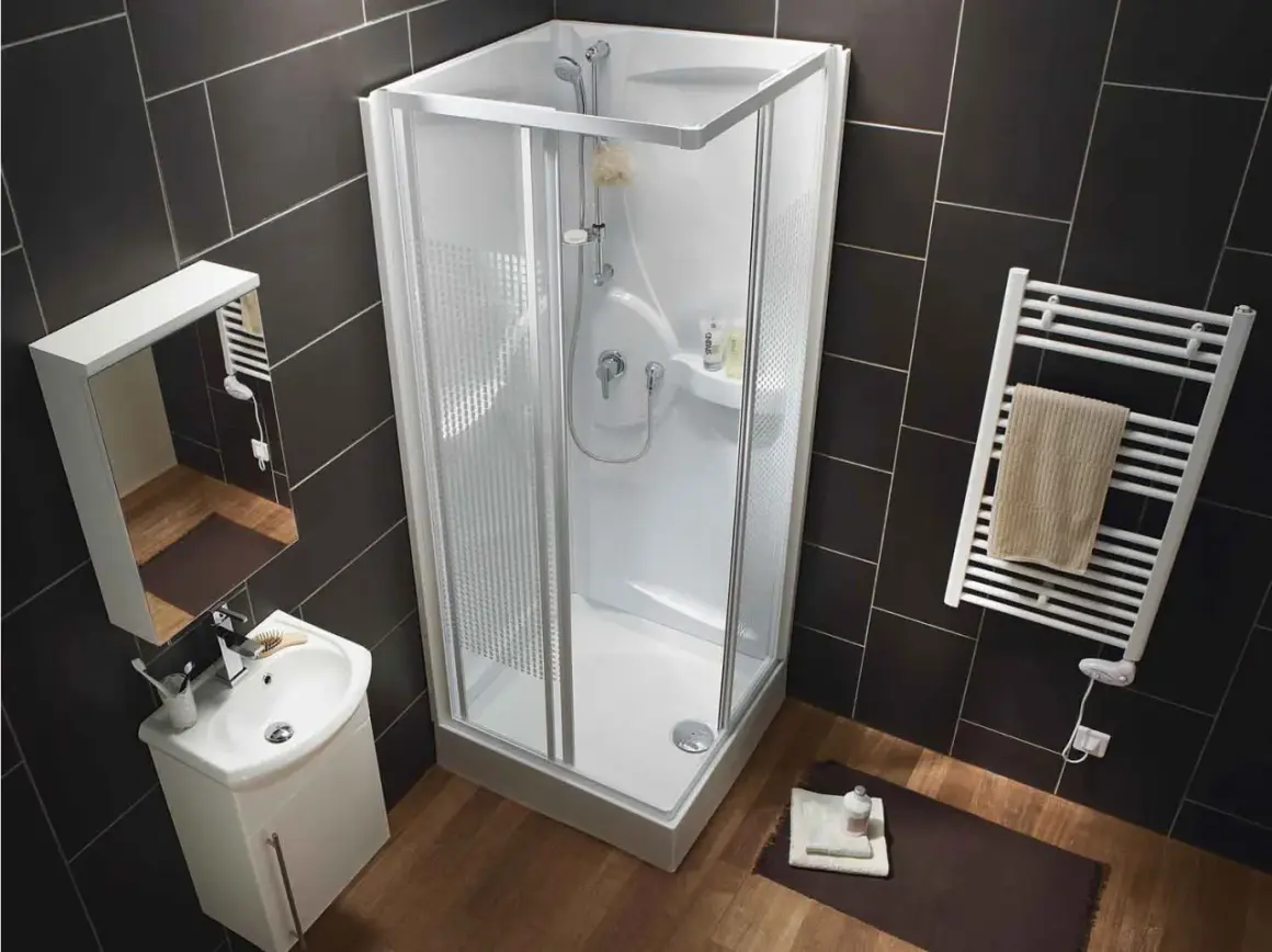 Salle de bain moderne avec douche d'angle, lavabo et sèche-serviettes. La dimension douche standard est bien représentée.