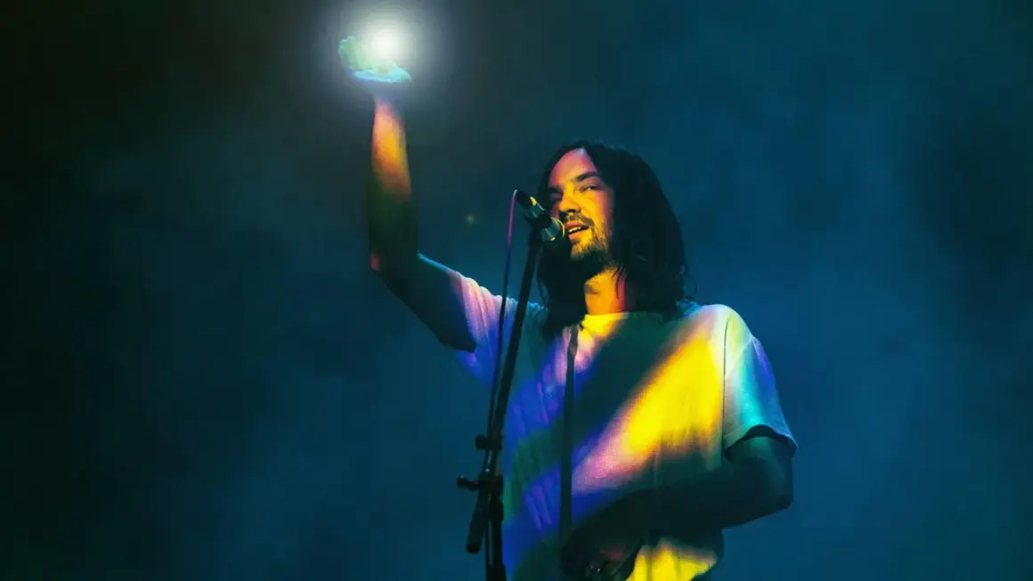 Kevin Parker von Tame Impala in Frankfurt, mit einem Lichtstrahl in der Hand.