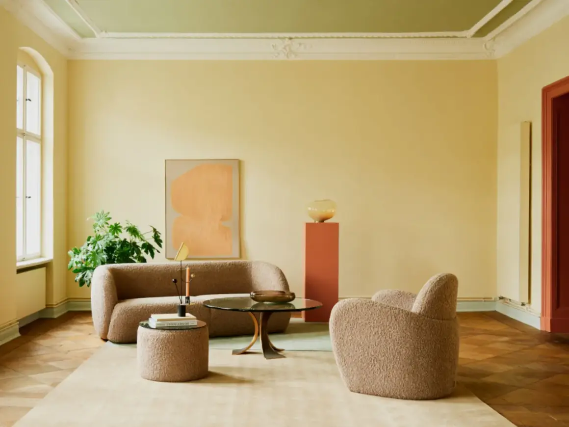 Gemütliches Wohnzimmer mit Bouclé-Möbeln und einem Kunstwerk. Die Decke wurde in einem frischen Grün gestrichen, was dem Raum eine besondere Note verleiht.