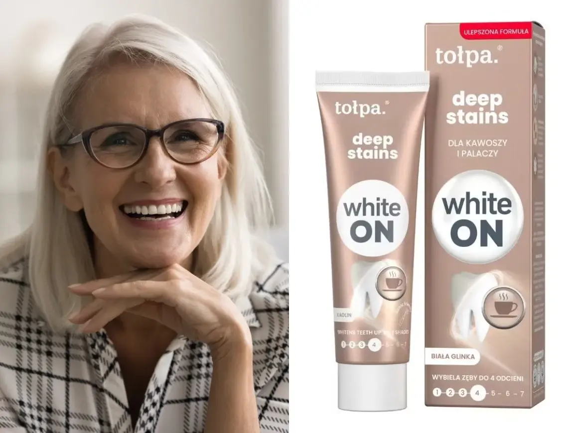 Uśmiechnięta kobieta z jasnymi włosami i okularami. Obok tubka i pudełko pasty do zębów Tołpa Deep Stains White ON – jaka pasta wybielająca dla kawoszy i palaczy.