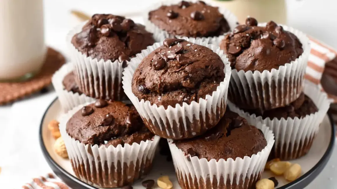Schokoladen-Protein-Muffins mit Schokostückchen und einer Prise Salz, appetitlich gestapelt.