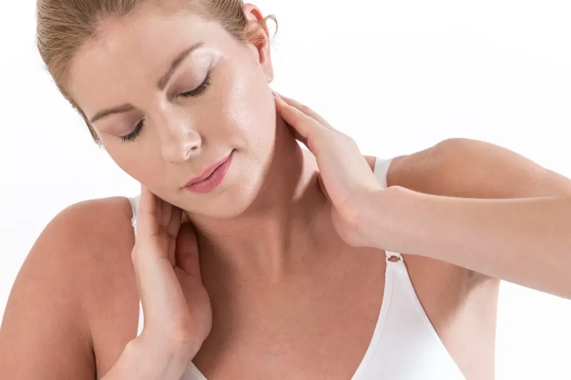 Femme se massant le cou, peut-être pour muscler son cou ou soulager une tension.