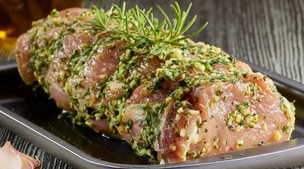 Schab w aromatycznej marynacie z czosnkiem i ziołami, gotowy do pieczenia.