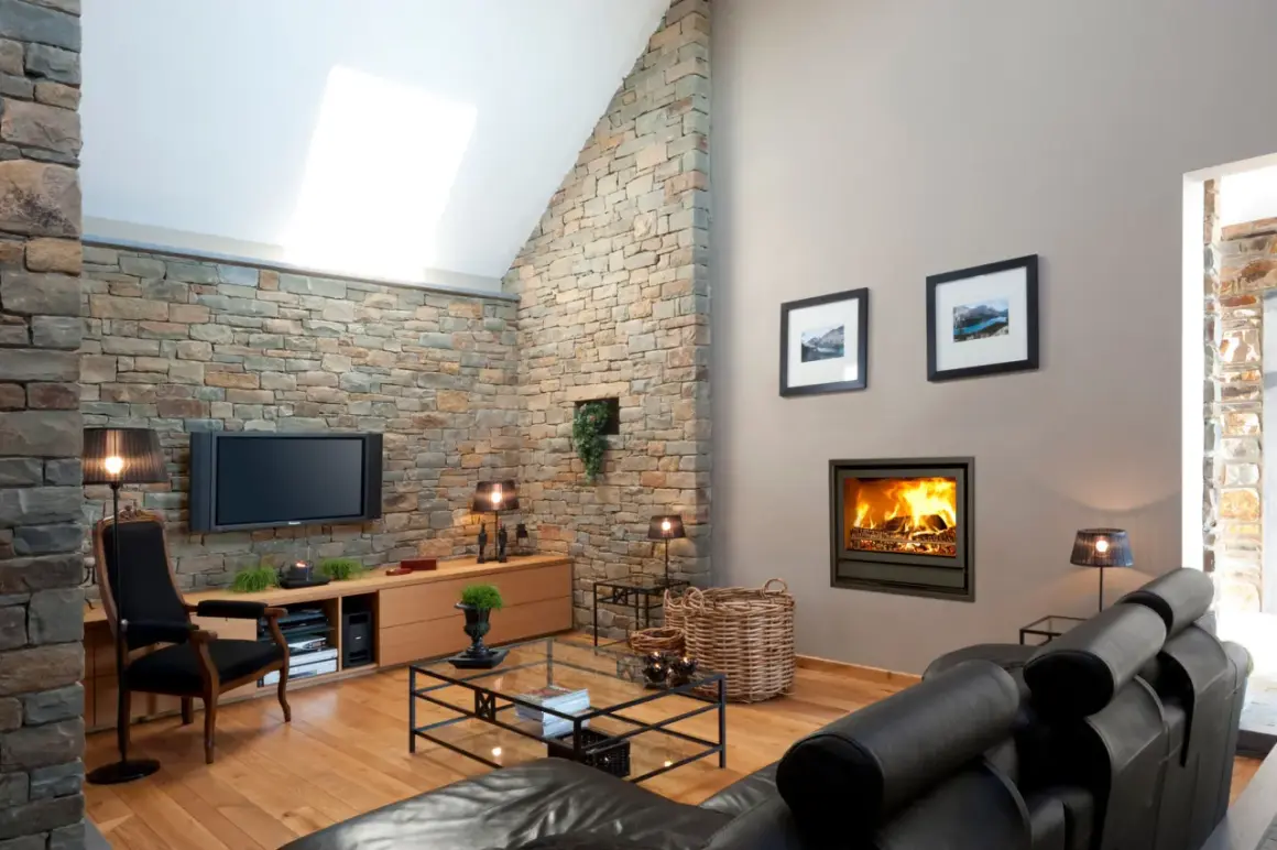 Gemütliches Fernsehzimmer einrichten mit Kamin, Ledersofa und Steinwand.
