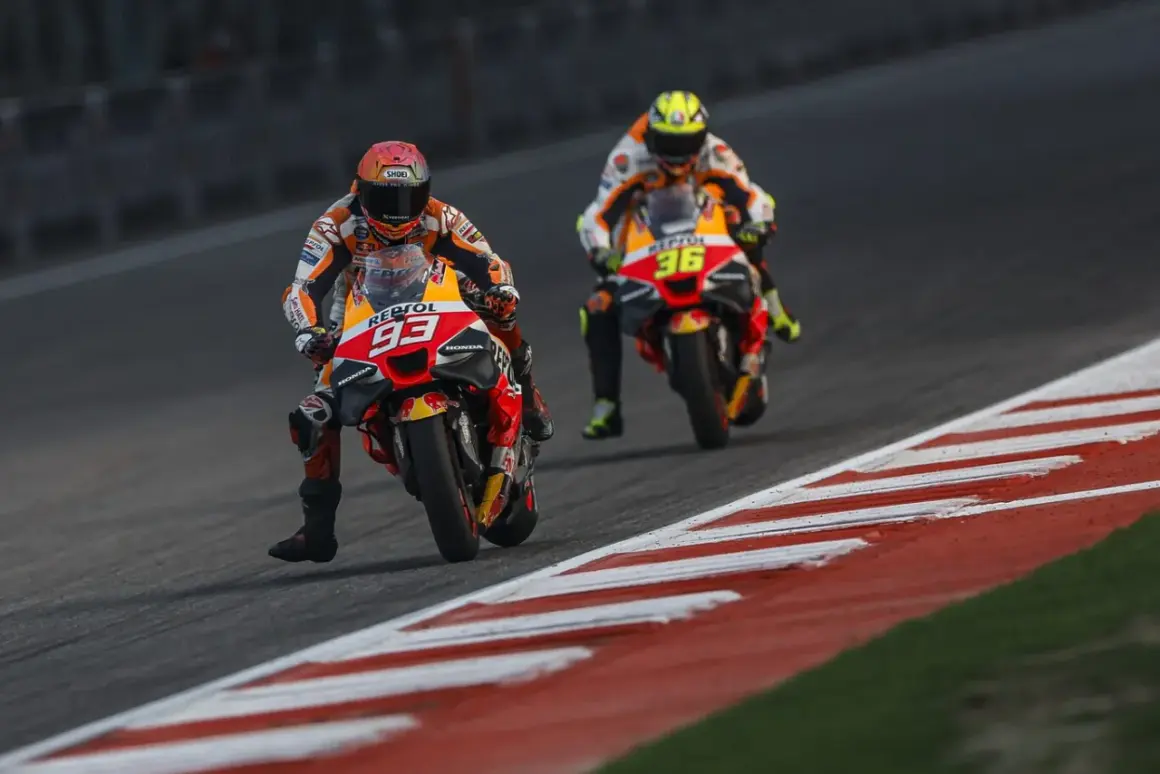 Dos pilotos de MotoGP compiten en una carrera. El piloto número 93 de Repsol Honda lidera, seguido de cerca por el piloto número 36. El coste de una moto de MotoGP es altísimo.