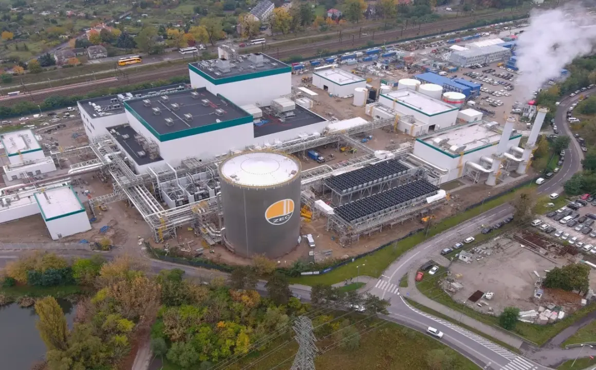 Budowa nowoczesnej elektrociepłowni, gdzie Polimex-Mostostal realizuje akcje. Widoczny ogromny zbiornik ZEC, instalacje i kominy.