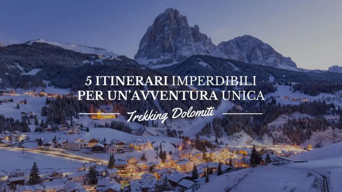 Paesaggio invernale con villaggio illuminato e montagne innevate. 5 itinerari imperdibili per un'avventura unica: Trekking Dolomiti.