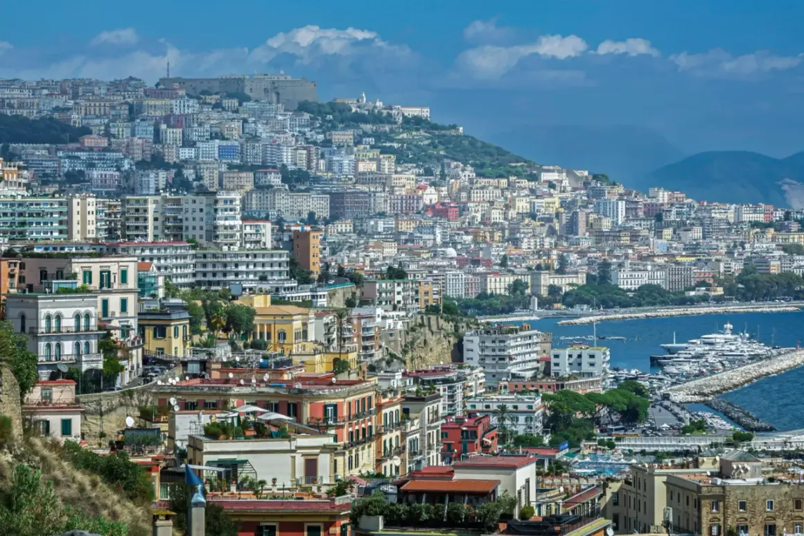 Panorama di Napoli con case colorate, il Vesuvio sullo sfondo e yacht nel porto. Come si dice in napoletano? "Napule è!