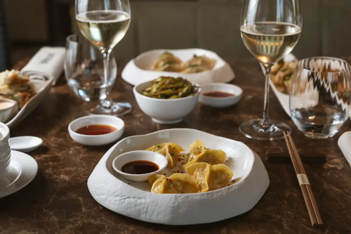 Ristoranti stellati Milano: un'esperienza culinaria con ravioli dorati, edamame e vino bianco.