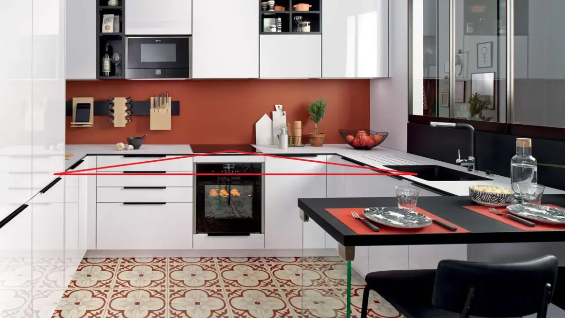 Cuisine moderne avec une organisation optimisée : tiroirs blancs, four encastré, crédence orange, et un îlot noir pour les repas.