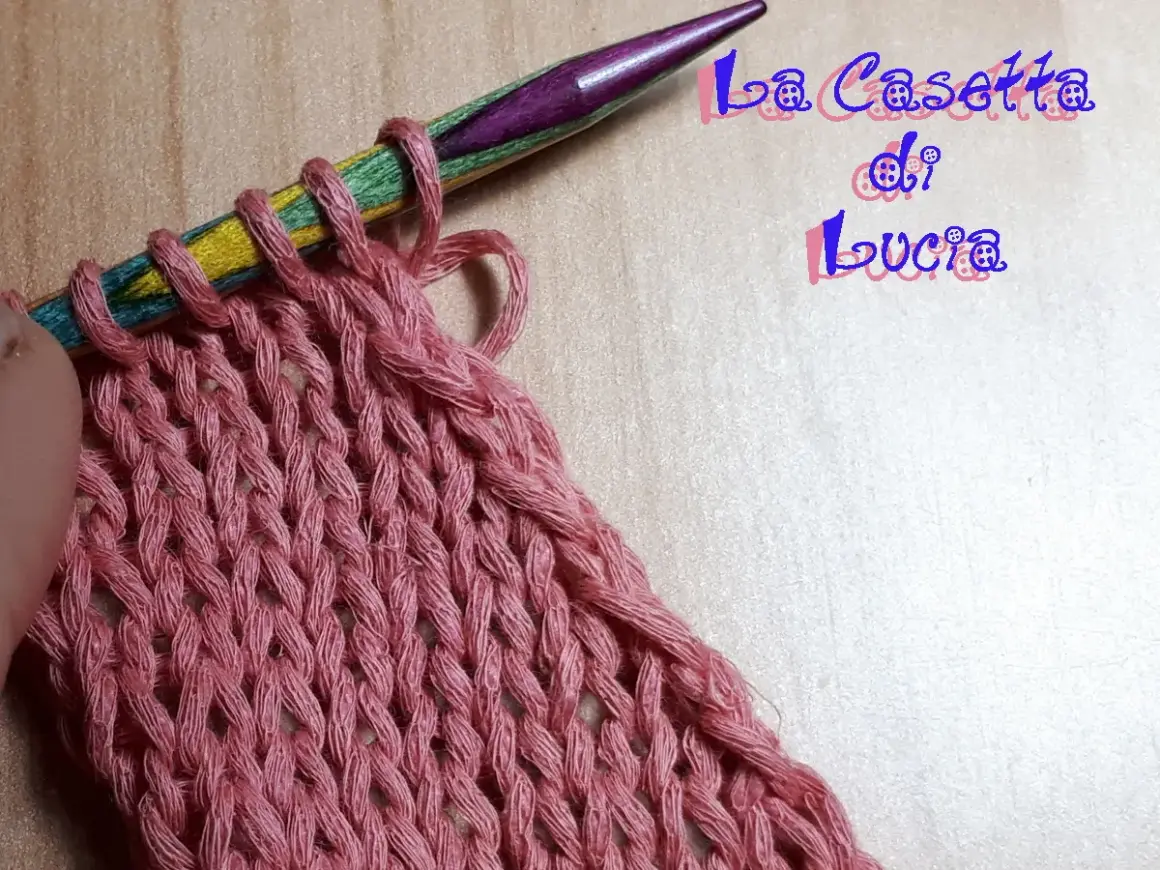 Uncinetto su ferri colorati, un lavoro a maglia rosa che ricorda un baktus.
