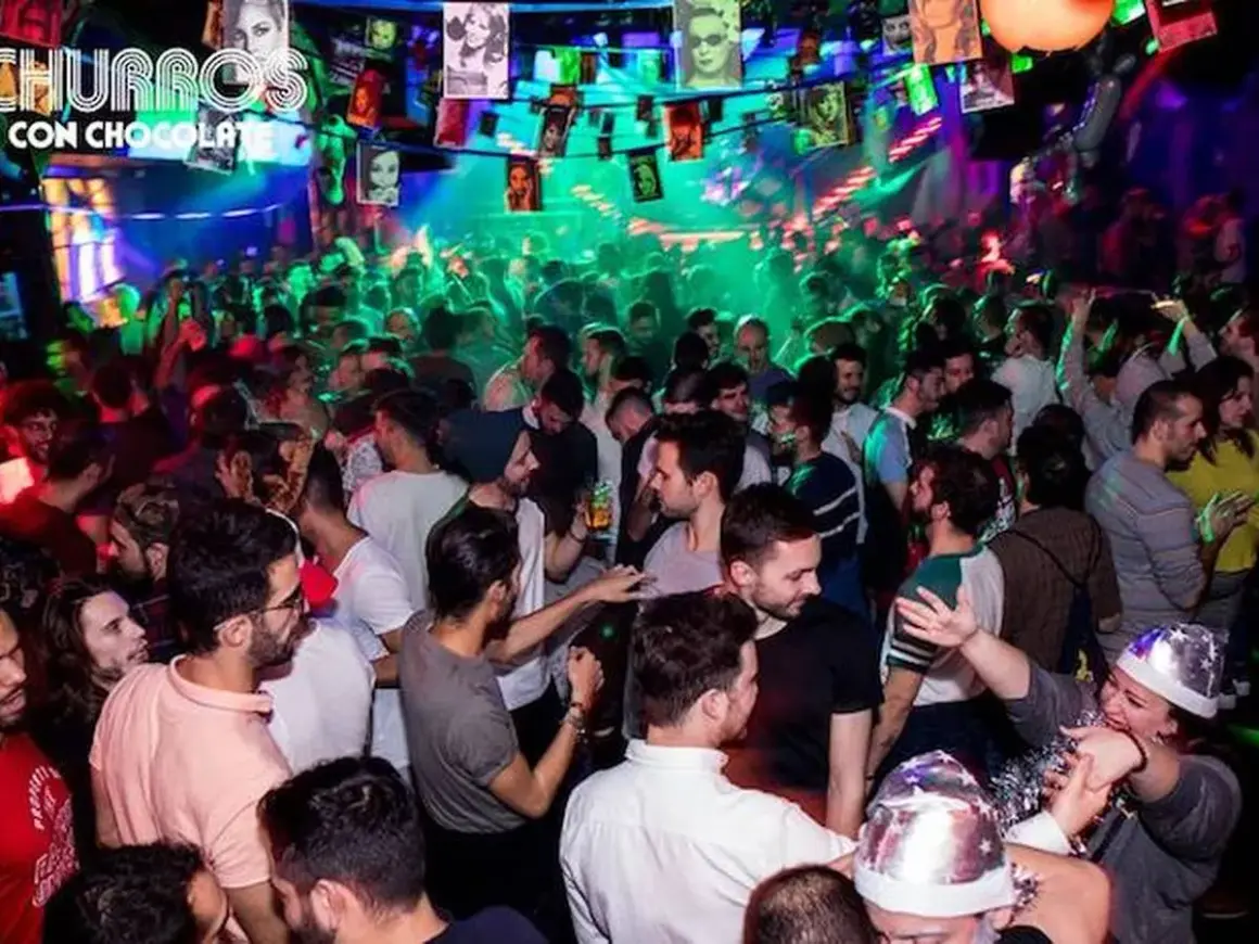 Festa vivace in una delle discoteche gay di Madrid, con luci colorate e gente che balla.