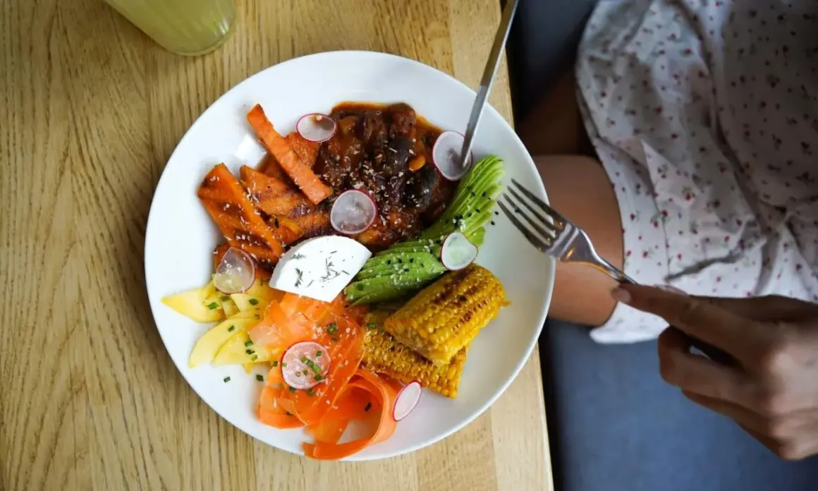 Assiette colorée avec carottes, avocat, maïs, fromage frais et viande en sauce. Une délicieuse alternative au riz pour un repas sain et savoureux.