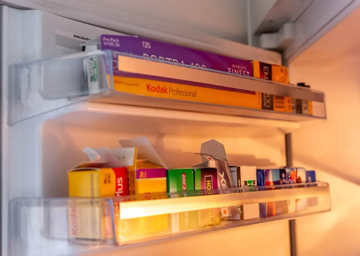 A collection of 35mm film rolls, including Kodak Portra 400 and Kodak Professional, stored in a refrigerator. These films are perfect for achieving that best 35mm film for vintage look.