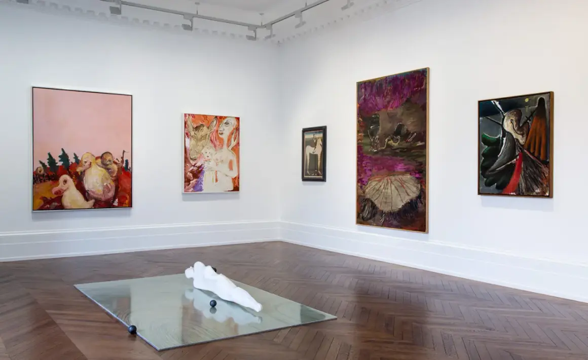 Artistic display at Michael Werner Gallery featuring abstract paintings and a sculpture on a mirrored surface.