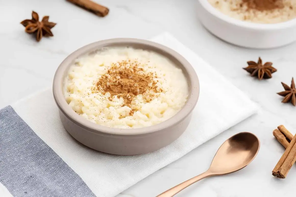Un tazón de arroz con leche cremoso, espolvoreado con canela. ¿Quién inventó el arroz con leche? Un misterio delicioso.
