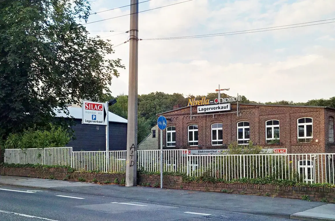 Ziegelgebäude mit Schildern "Nivella-chromolit Lagerverkauf" und "SILAG Handel AG Lagerverkauf" in Piepersberg, Solingen.