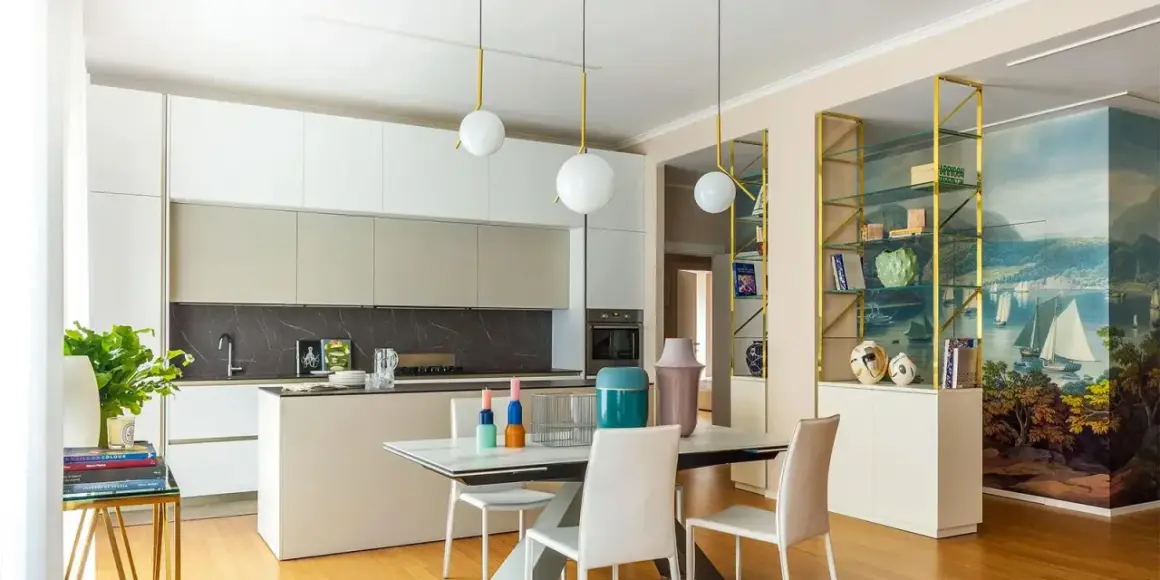 Cucina moderna con isola e zona pranzo. Parete con libreria dorata e affresco marino, un'ispirazione per idee pareti soggiorno moderne.
