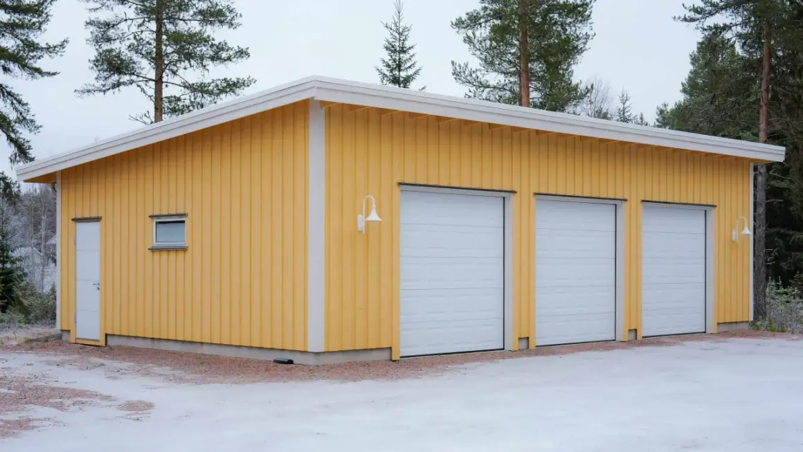 Gult garage med tre vita garageportar, redo att måla om.