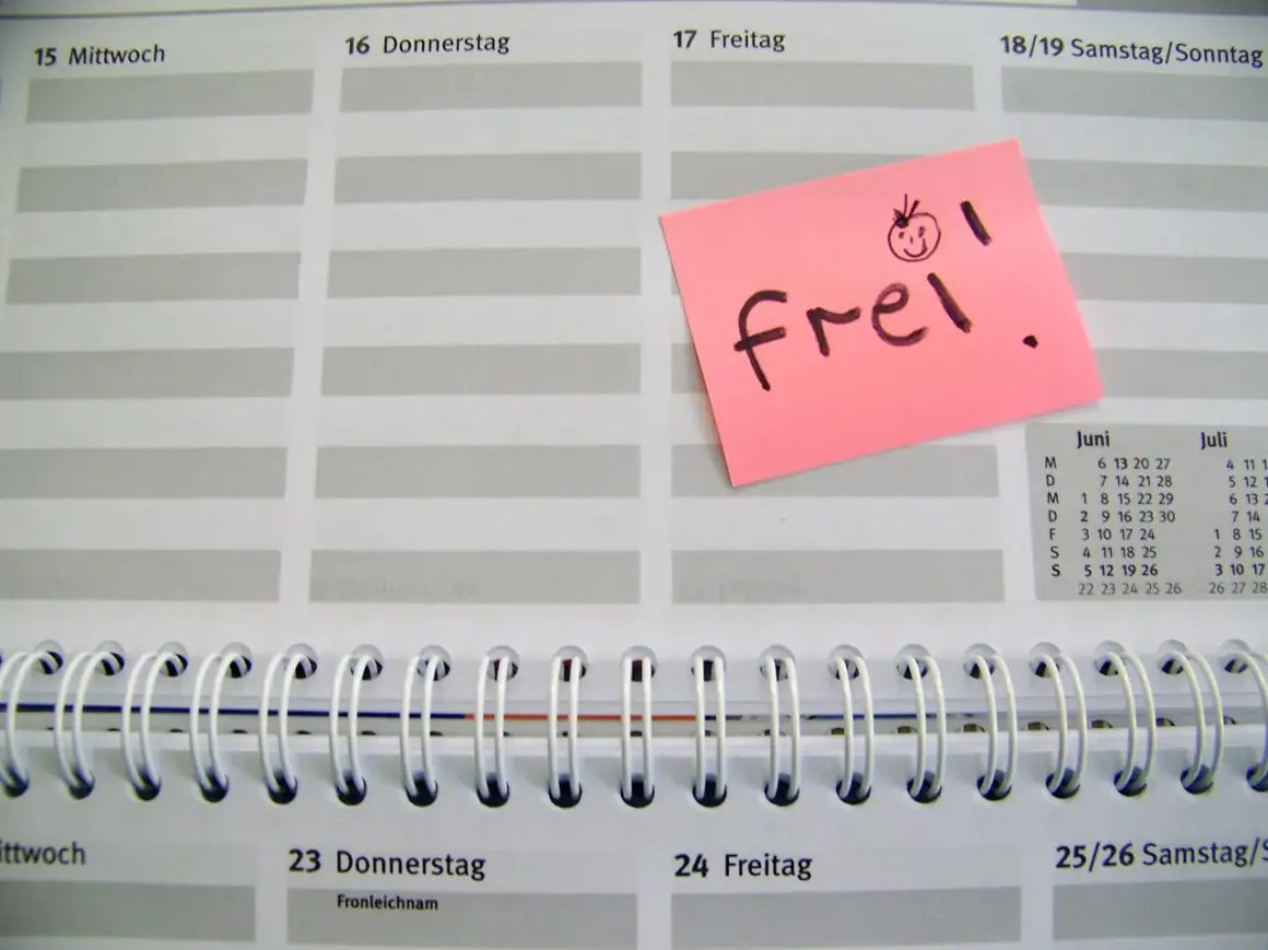 Ein rosa Zettel mit "frei!" und einem lachenden Smiley auf einem Kalenderblatt. Der Zettel könnte für den Freizeitausgleich nach Krankheit stehen.