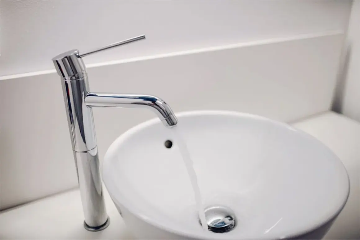 Grifo moderno y lavabo blanco. ¿Buscas el precio reforma baño 4 m2?