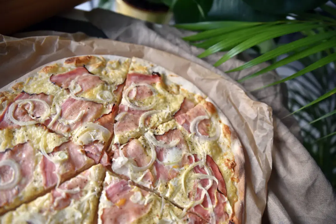 Pyszna pizza z szynką i cebulą, idealna na szybki obiad. Jaka szynka do pizzy? Najlepiej delikatna, która nie zdominuje smaku.