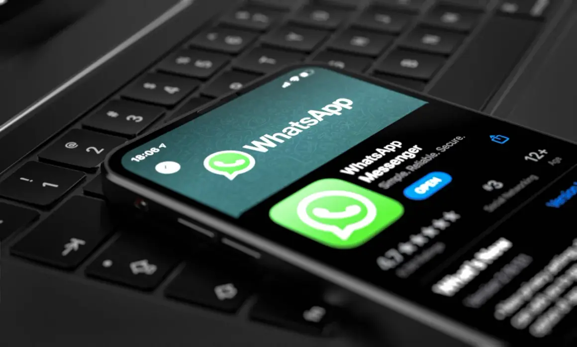 Smartfon z aplikacją WhatsApp na klawiaturze laptopa. Teraz możesz korzystać z WhatsApp na komputerze.
