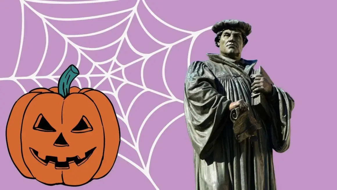 Reformationstag statt Halloween: Martin Luther Statue neben Kürbis und Spinnennetz.