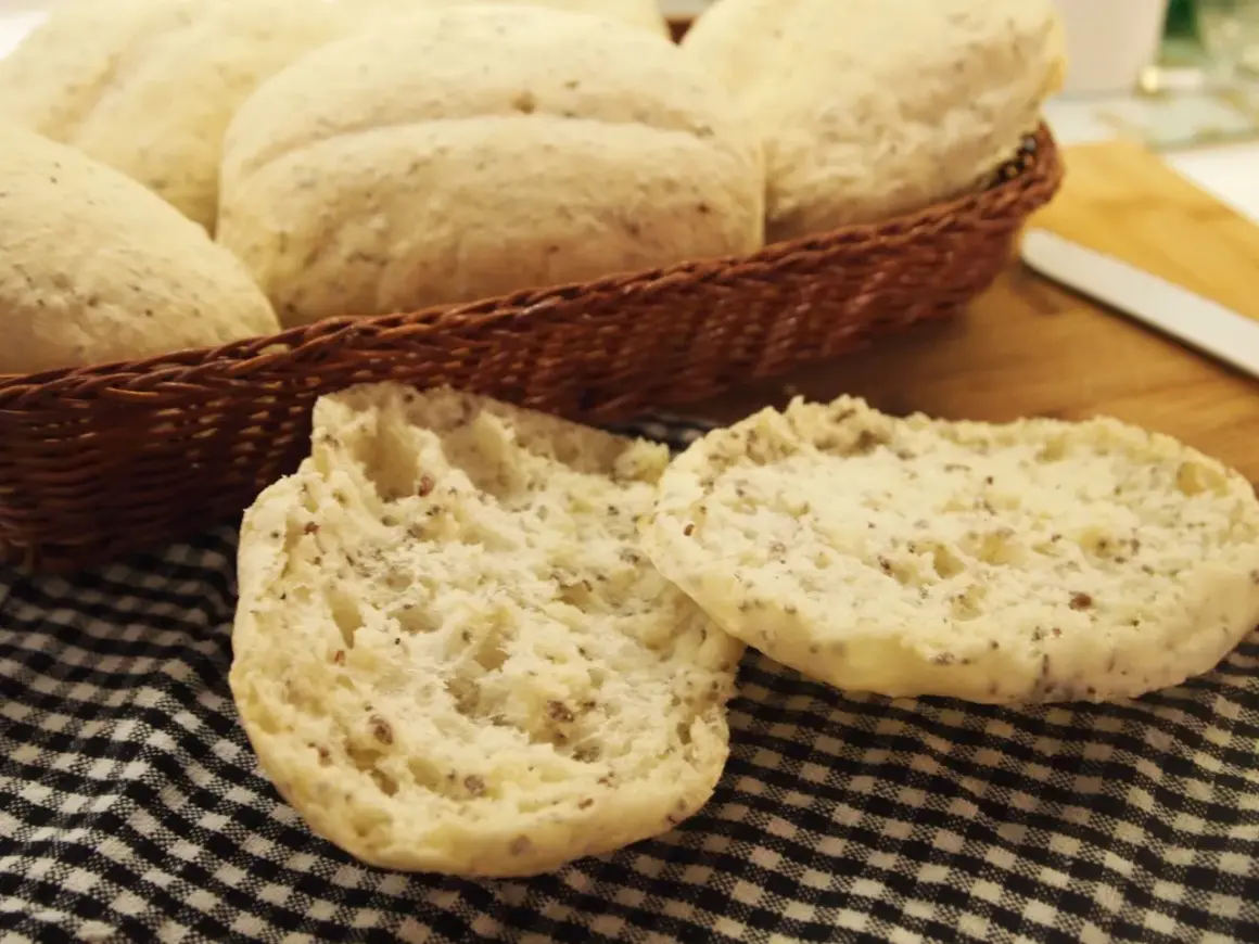 Puszyste bułki bezglutenowe, idealne na śniadanie, leżą w koszyku i na czarno-białej kratce.