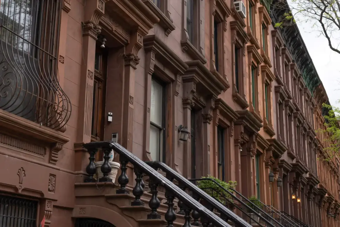 Brązowe kamienice w stylu brownstone, typowe dla Harlem, Nowy Jork, z ozdobnymi detalami i schodami.