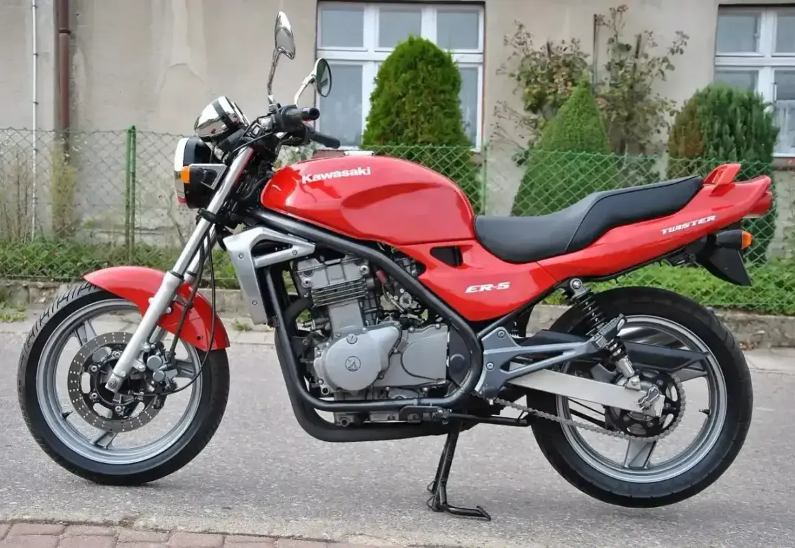 Czerwony Kawasaki ER-5, gotowy do jazdy po miejskich ulicach. Klasyczny wygląd i niezawodność.
