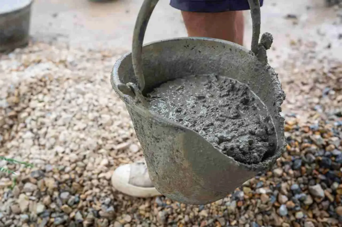 Secchio pieno di cemento fresco, pronto per essere utilizzato. Imparare come fare il cemento è fondamentale per ogni progetto di costruzione.