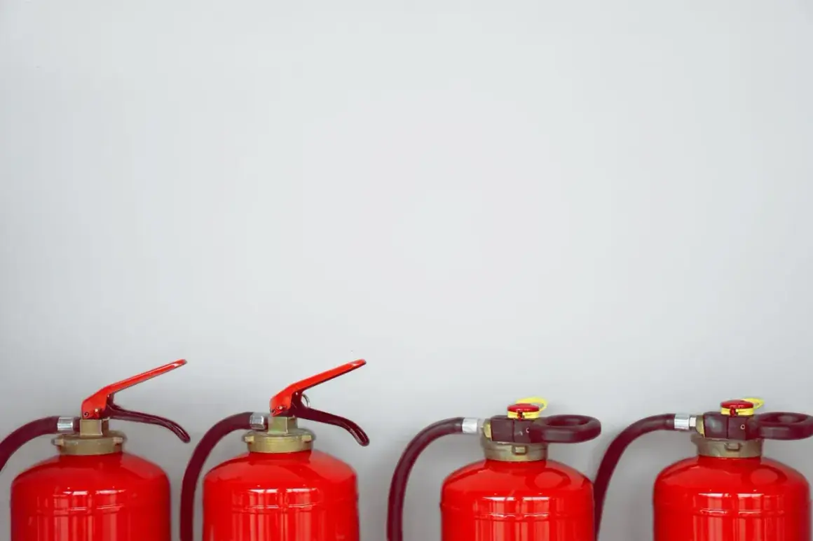 Vier rote Feuerlöscher stehen nebeneinander. Sie enthalten ABC-Pulver, das bei Bränden nützlich ist, aber nicht giftig ist.