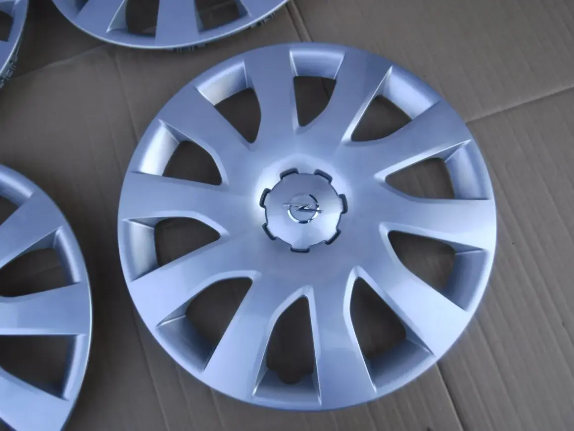 Srebrne kołpaki Opel Vivaro z logo marki. Komplet czterech sztuk, idealny do odświeżenia wyglądu Twojego auta.