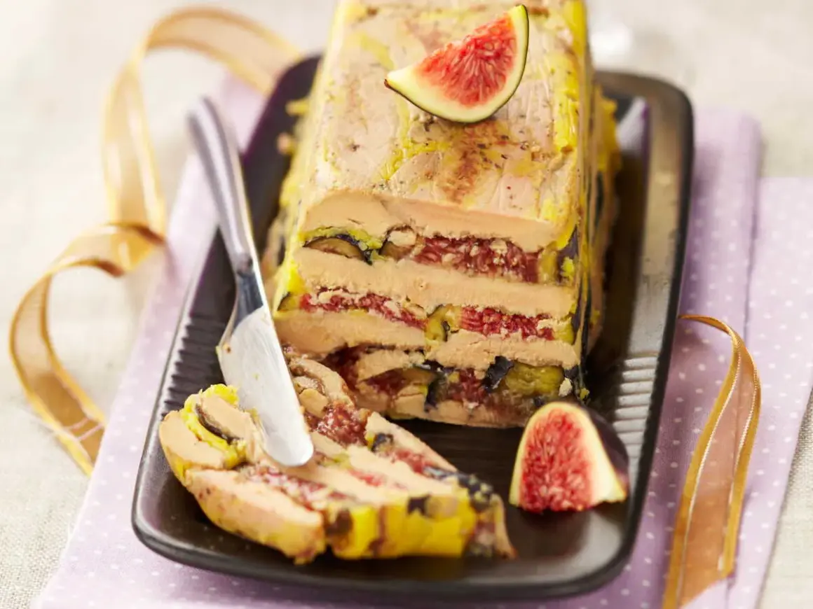 Un pressé de foie gras aux figues, une tranche est coupée, prête à être dégustée.