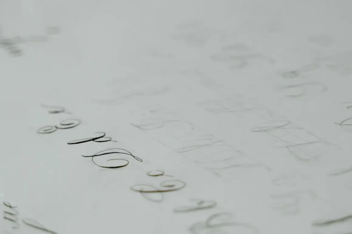 A page of practice calligraphy, with elegant loops and swirls in cursive, showing the careful strokes of a pen.