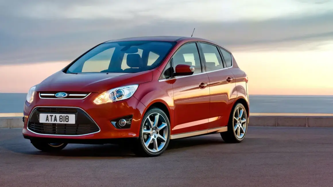 Röd Ford C-Max parkerad vid havet. Inga problem här, bara en vacker vy.